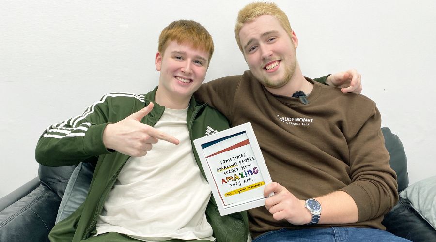 Two young men who are care leavers hugging and looking at the camera