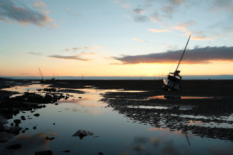 Coastal scene at dusk from Heswall, Wirral, with a moored boat on the right hand side.