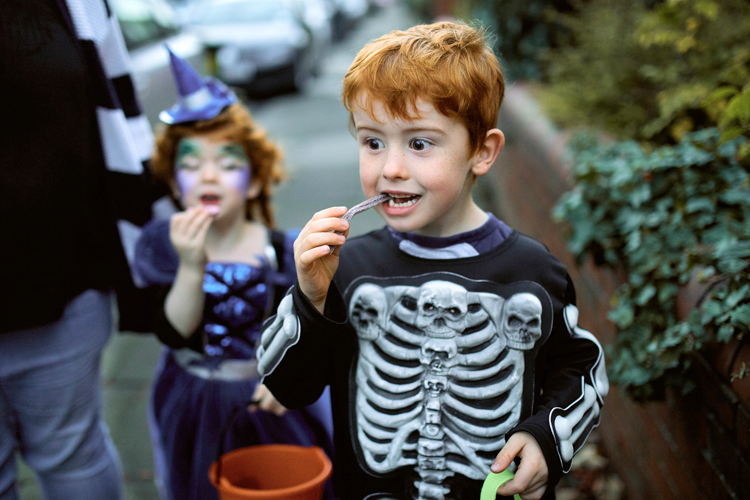 Young children dressed in Halloween costumes and trick or treating