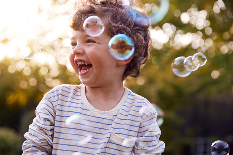 Child surrounded by bubbles 