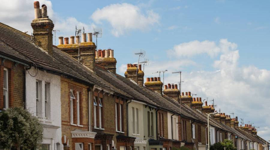 A stock images showing a row of terraced houses set against a blue and cloudy sky