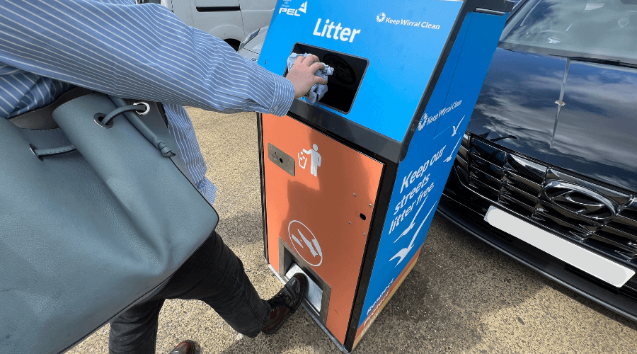 Person putting rubbish in one of the solar bins