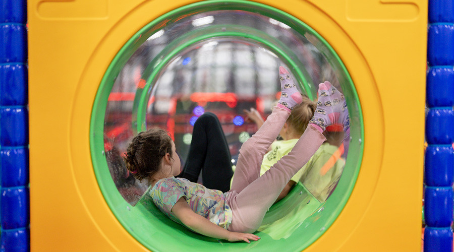 Two children play in a soft play area