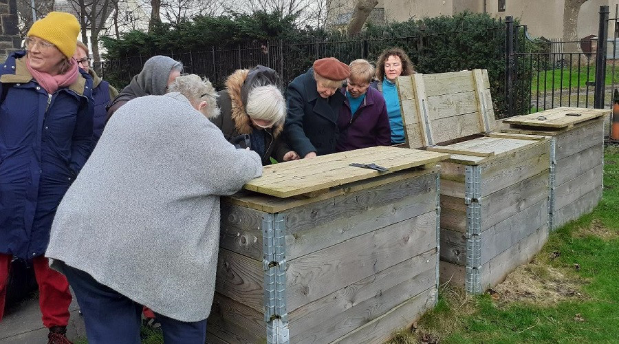 Volunteers using one of the community composters