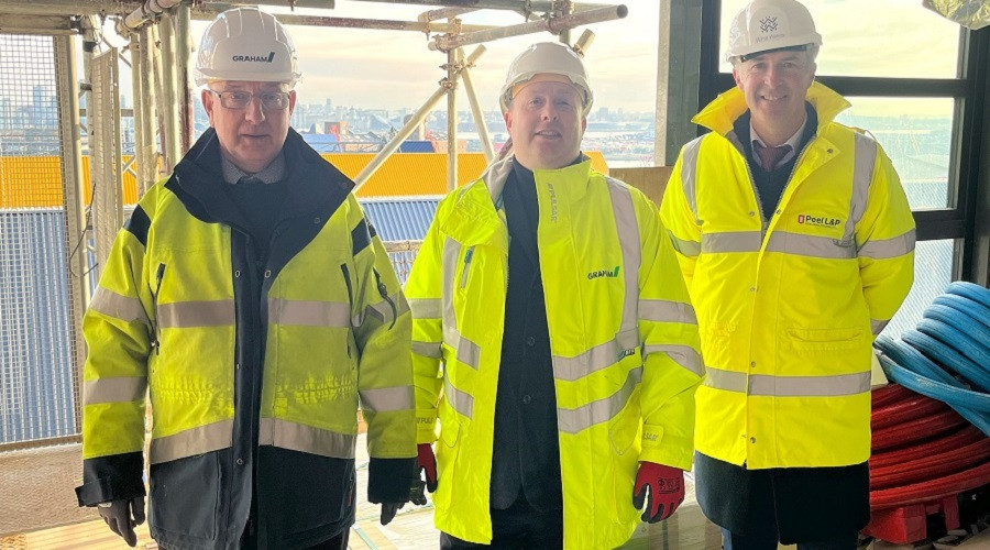 wearing his vis jackets and hard hat From left: Graeme Moffat, Contracts Director at GRAHAM; Cllr Paul Stuart, Leader of Wirral Council; and Richard Mawdsley, Development Director at Wirral Waters. Image courtesy of Peel Waters