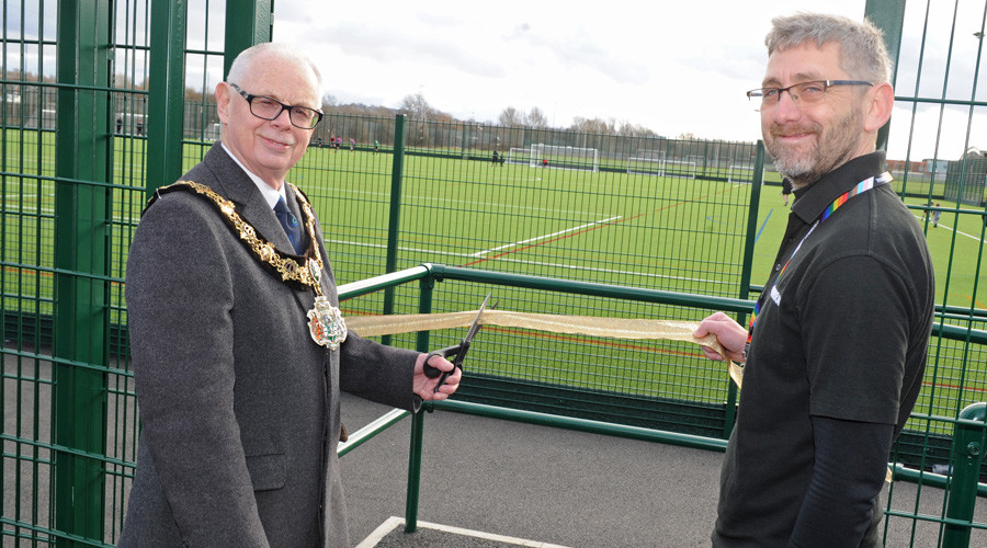 Mayor of Wirral Cllr Jerry Williams cutting a ribbon next to the new pitch, alongside Joe Wilson leisure manager
