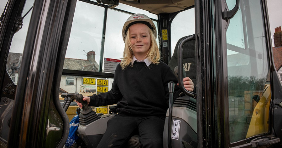 A pupil from Grove Street primary school in the cab of a digger at New Ferry