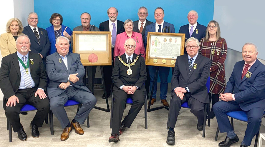 Mayor Jerry Williams joined by 14 other former Mayors of Wirral. They are pictured with the original Royal Charter, featuring the large red wax seal of Queen Elizabeth II and the original coat of Arms for Wirral, which is still used for civic purposes today. 