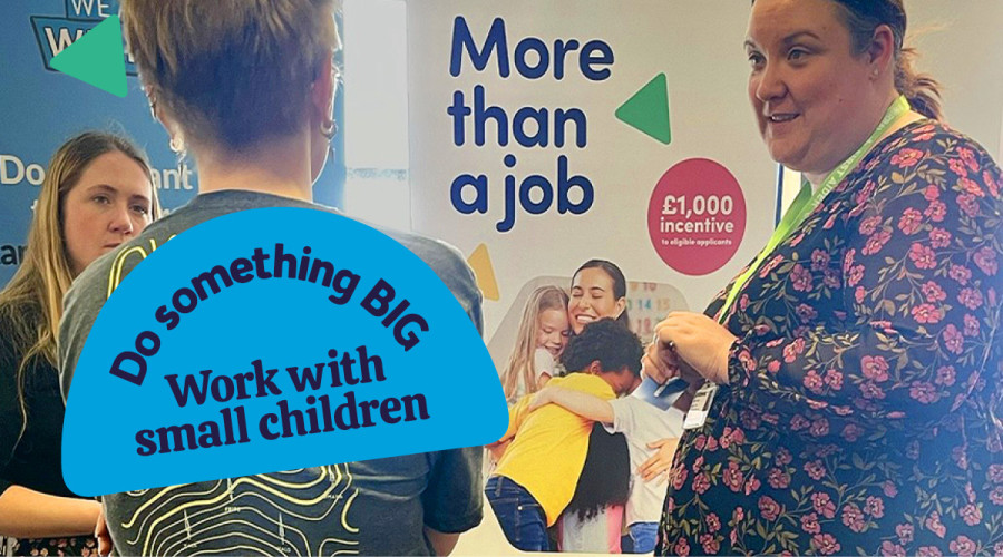 Two people talking to a possible recruit at a job fair