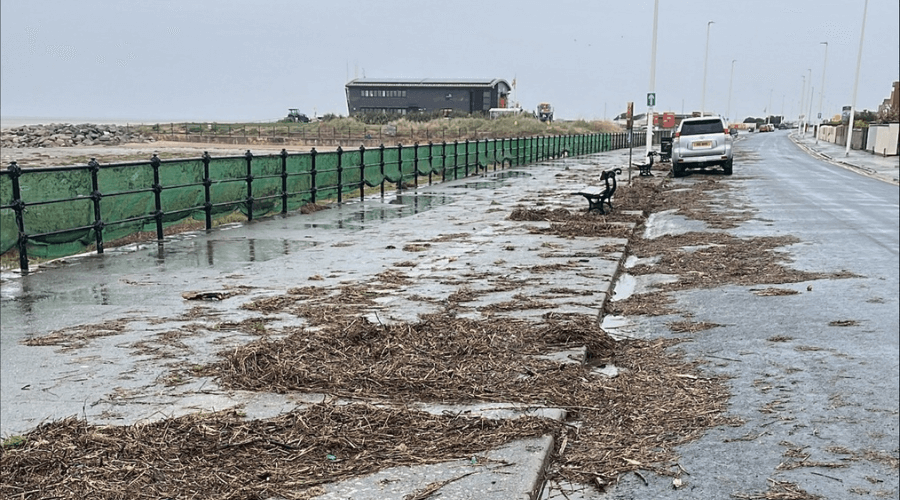 debris spread across the pavement at road along Wirral's coastline