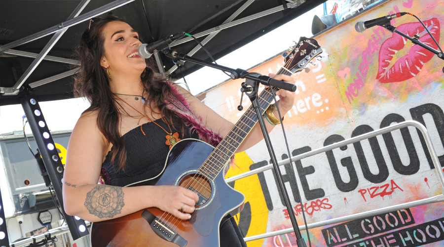 musician performing on stage with acoustic guitar