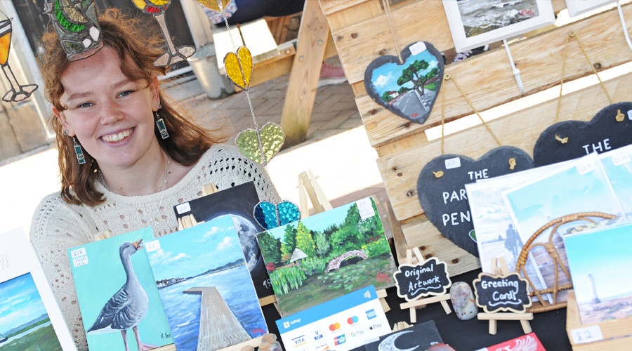 One of the young traders with some of her artwork in the foreground