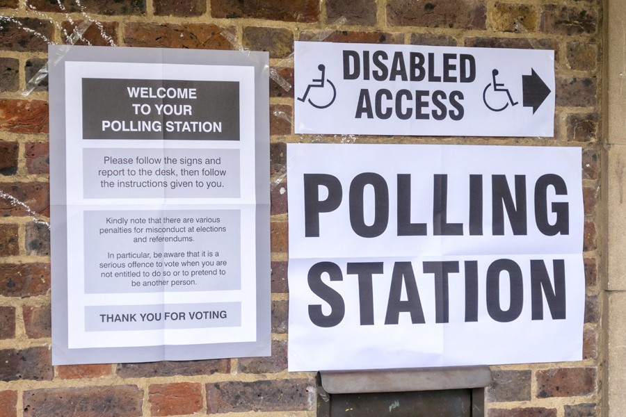 Photo of signs on a wall outside a polling station