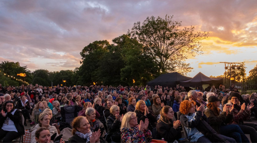 Large crowds watching live music on Thursday night as the sun sets.