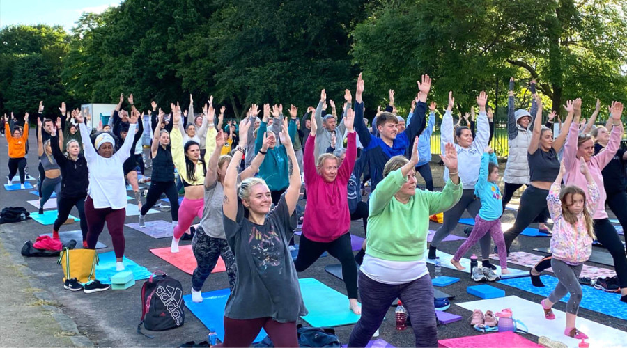 Almost one hundred people taking part in a yoga class in front of Gaia.