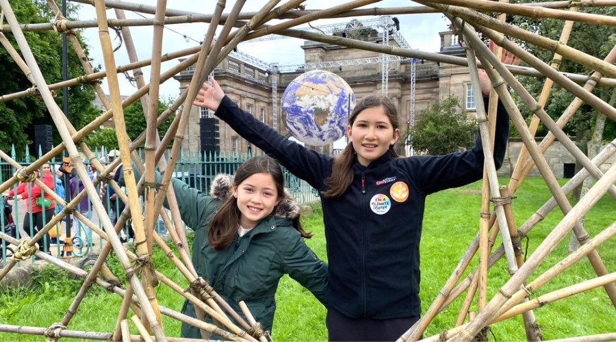 Children posing with bamboo sculpture.