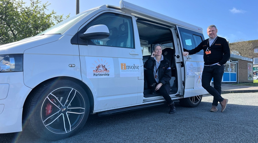 Two members of the reachout team standing in front of their van