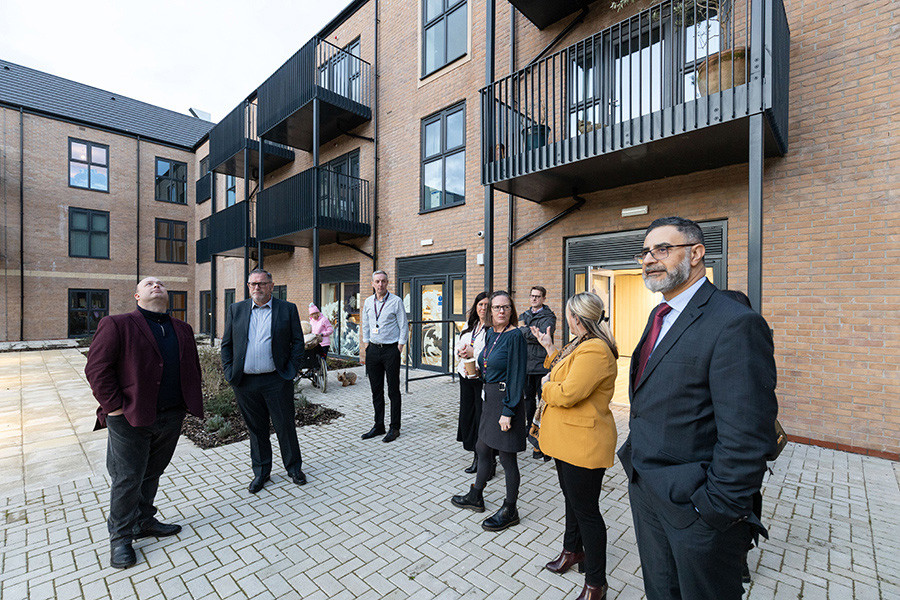 People standing outside spinnaker house looking at the exterior