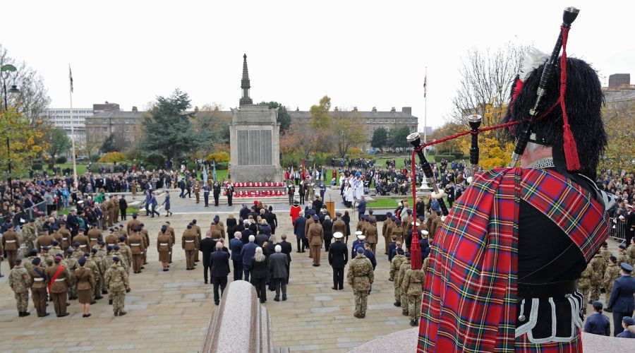 Photo of a Piper playing over a packed Hamilton Square