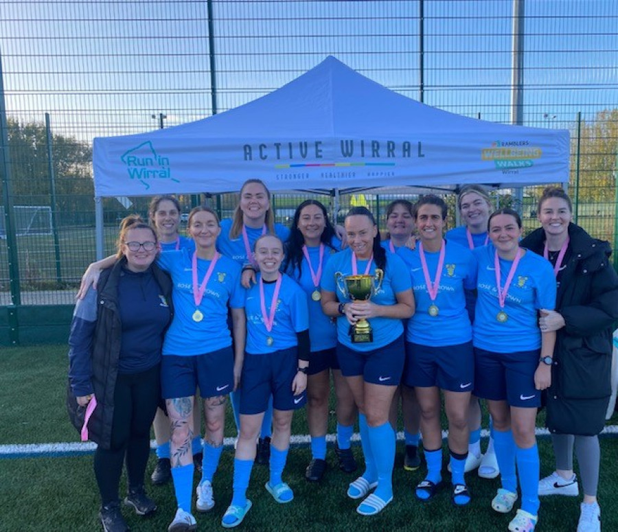 Winning football team smiling with medals and trophy