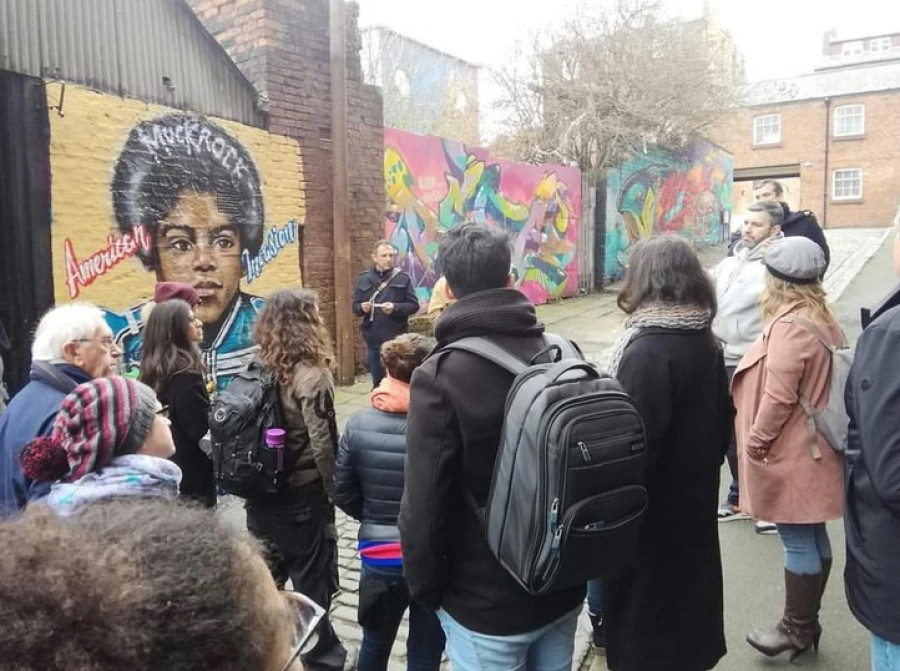 People stood looking at a graffiti mural 