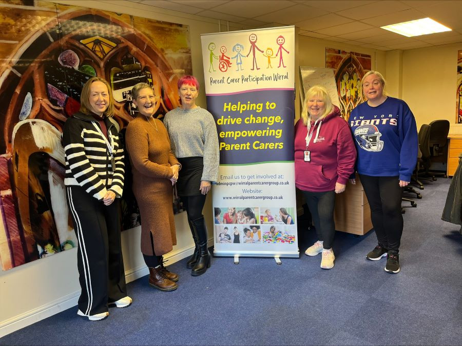 Five women standing next to a Parent Carer Participation Wirral banner