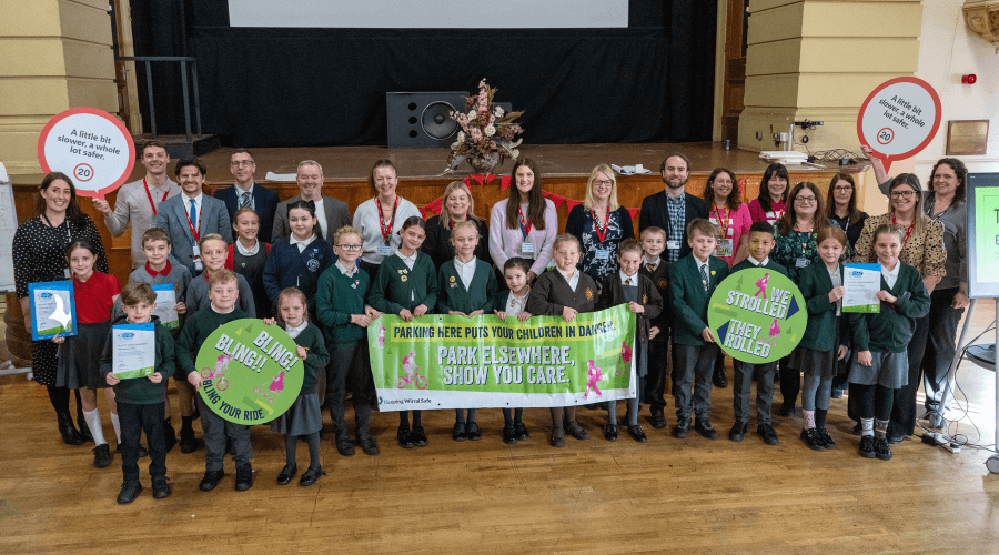 Group of school pupils and their teachers holding signs about active travel