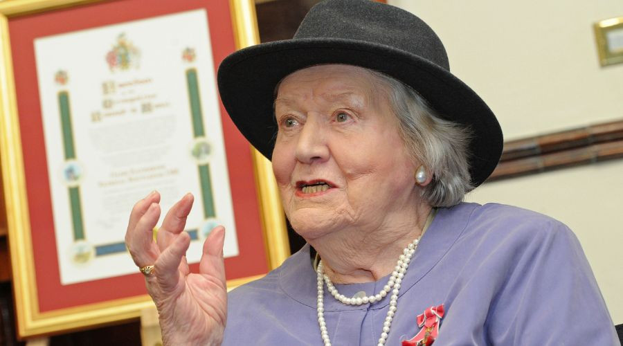 Photo of Dame Patricia Routledge in front of her Freedom of the Borough Scroll.