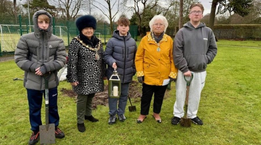 Local schoolchildren line up with the Mayor and Mayoress after planting a tree on Holocaust Memorial Day