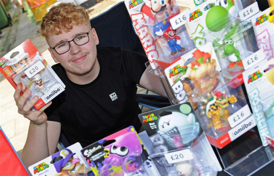 A trader at a previous Youth Market event sits behind his stall with cartoon figures he is selling