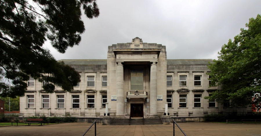 Birkenhead library from the front. A white Building with a large archway at the front.