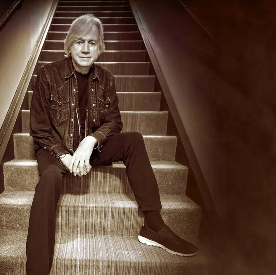 Justin Hayward sitting on stairs