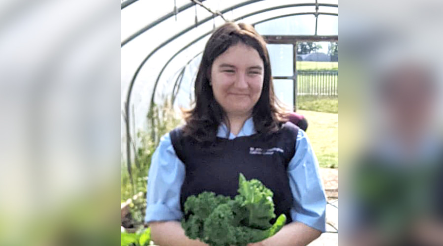 Close up of Gabby holding variety of green vegetables