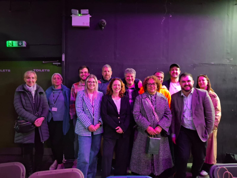 Photo of a group of people smiling in a dimly lit room