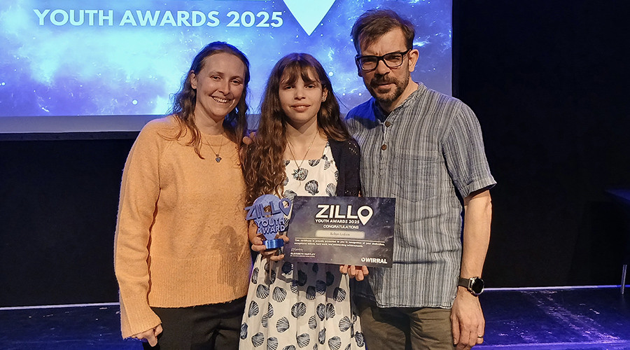 robyn smiling with her zillo award alongside her parents