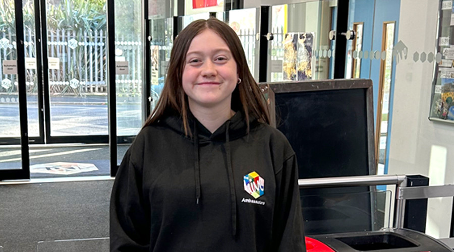 charlotte smiling at the hive in a hive hoody