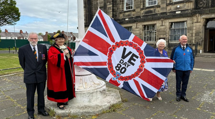 Photo of the Mayor, Mayoress and veterans raising the VE Day flag at Wallasey Town Hall