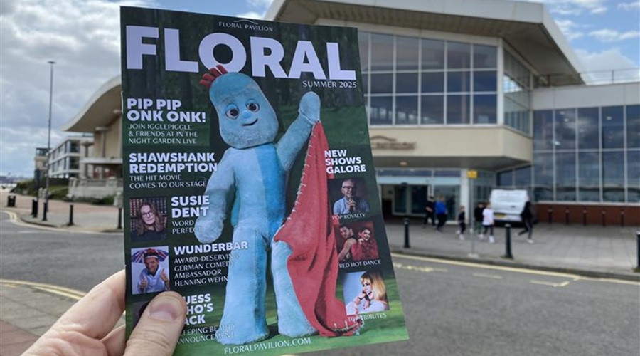 Floral Brochure being held up, with theatre in background