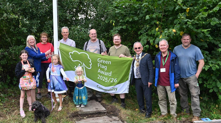 Group of people with Wirral's Mayor Brian Kenny holding a Green Flag