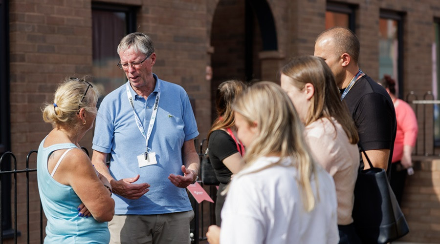 Residents gather outside the new apartments in New Ferry as part a community event