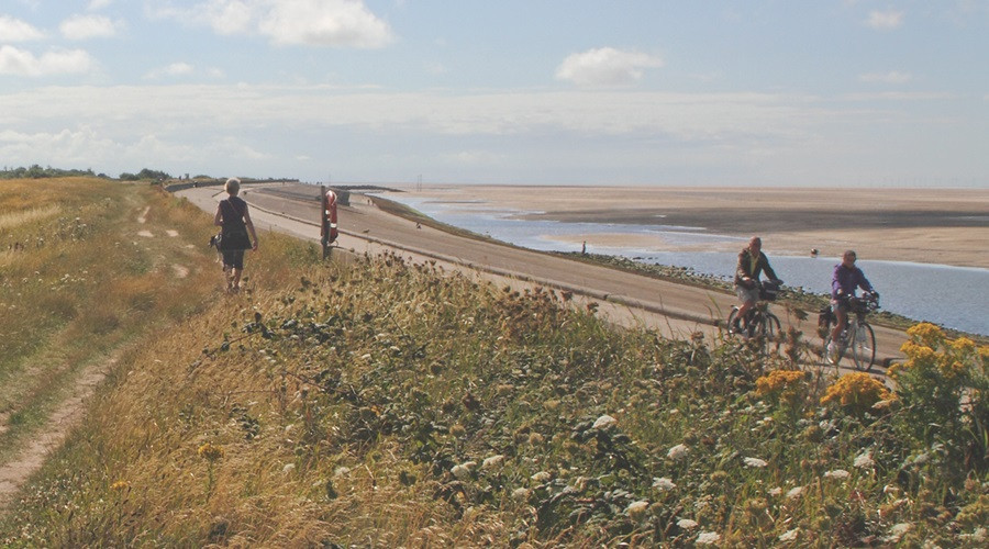 A photograph of walkers and cyclists using the North Wirral coastal path