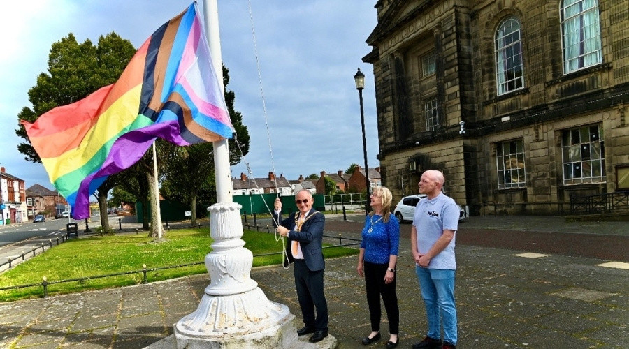 Photo of the  pride flag being raised