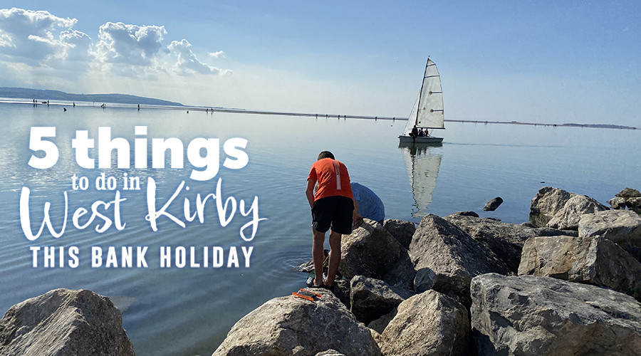 Photo of a boy looking into the water at West Kirby marine lake with a sailboat in the background. With the words 5 things to do in west Kirby this Bank Holiday
