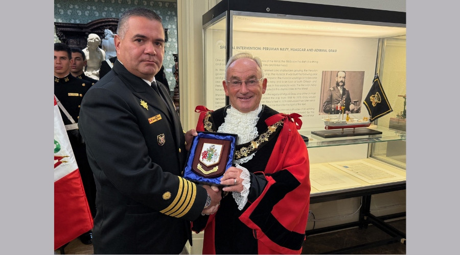 Photo of The Mayor of Wirral presenting a civic crest to the Captain of BAP Union after unveiling a new display at the Williamson Art Gallery on Peru's links with Laird Brothers shipyard
