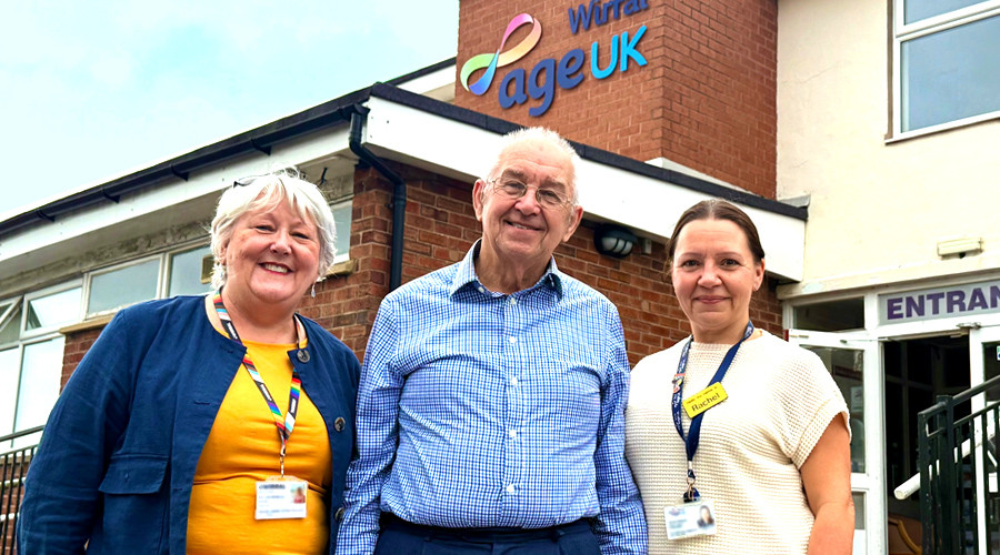 three people smiling outside age uk wirral