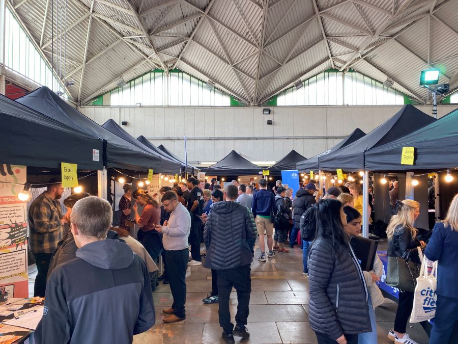 Lots of people shown browsing stalls at a jobs fair in Birkenhead Market
