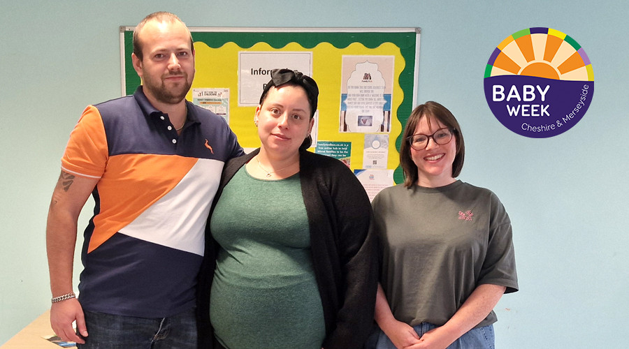 Three adults standing together in front of an information board. The board displays various posters and notices. On the right side of the image, there is a colorful circular logo with the text “Baby Week Cheshire & Merseyside.