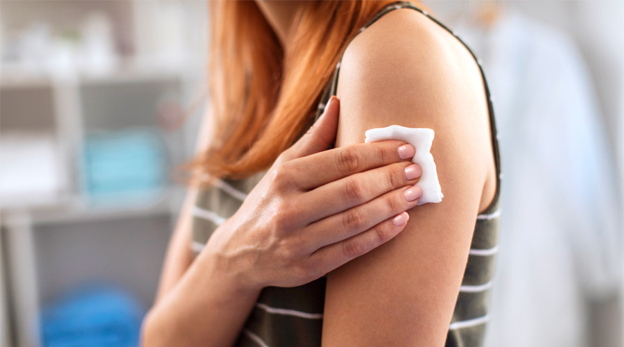 picture of woman's arm with cotton wool held over a vaccination site