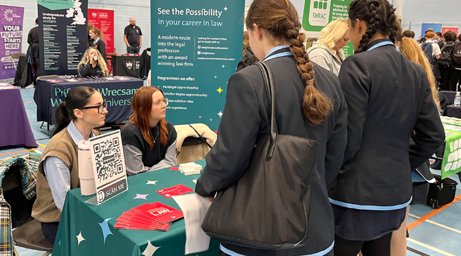 students speak with an exhibitor at careers fair