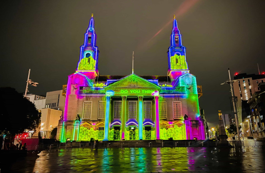 An old building in Liverpool lit up in rainbow colours at night